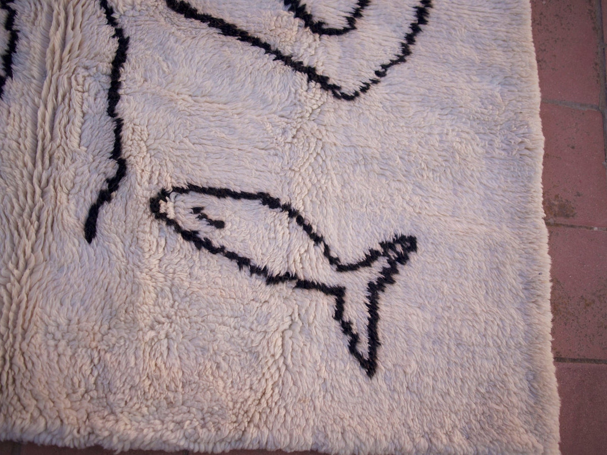 Close-up detail showcasing the fish motif on the white and black Beni Ourain Moroccan rug.