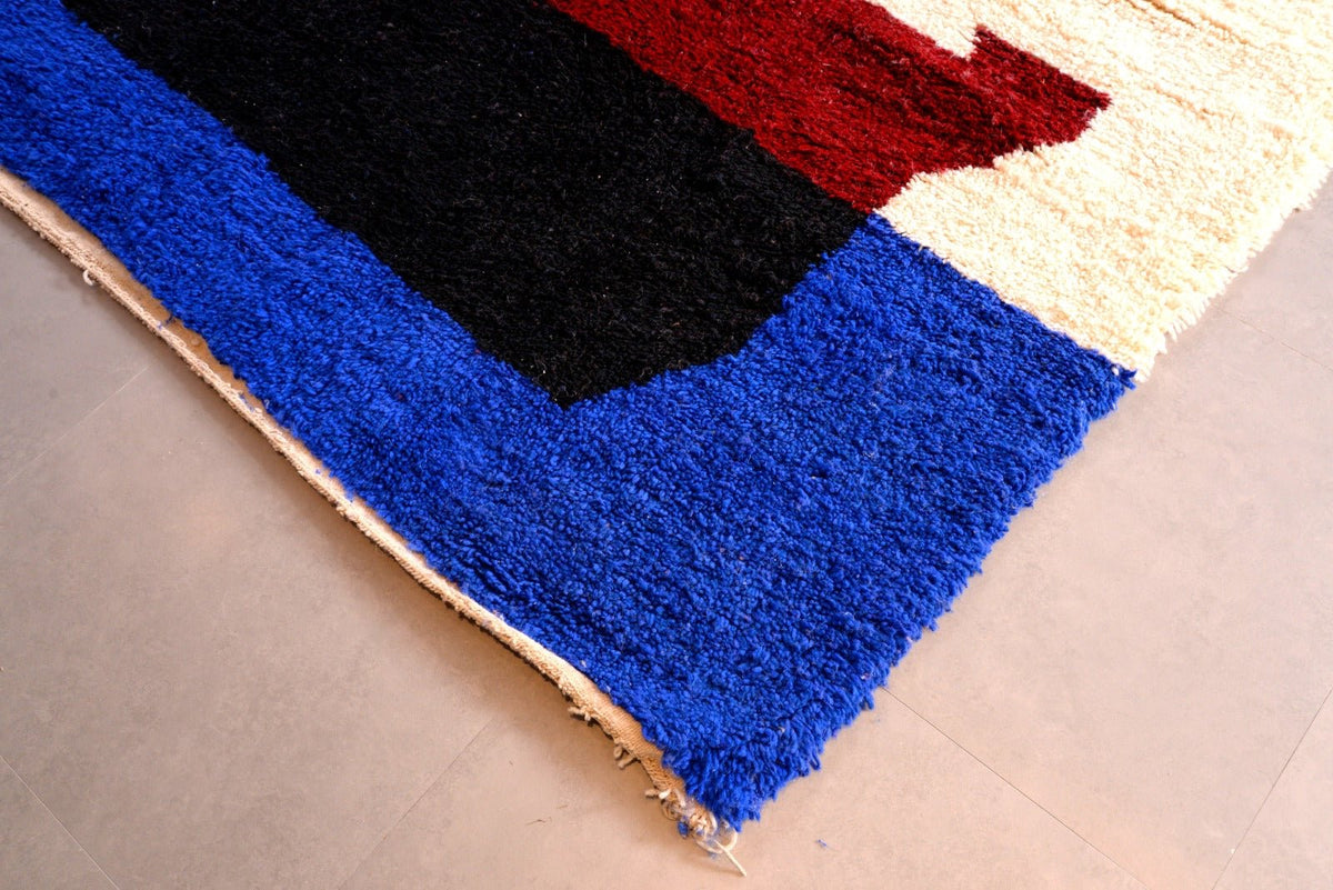 Front view of a blue Moroccan Beni Ourain rug with a geometric design and fringe edges.