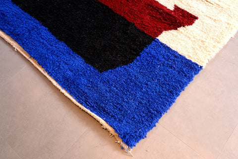 Front view of a blue Moroccan Beni Ourain rug with a geometric design and fringe edges.