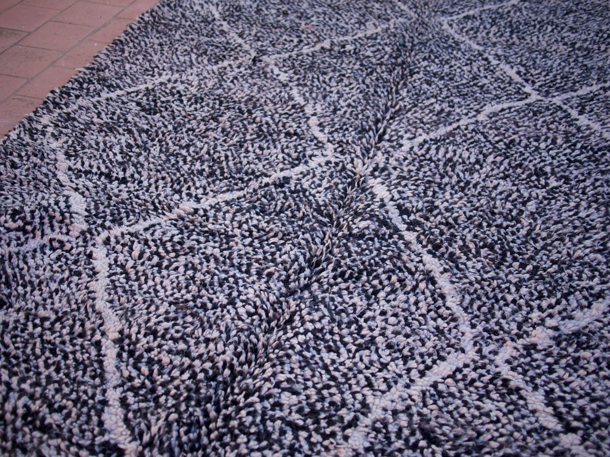 Close-up view of the black and white geometric pattern on the Beni Ourain rug.