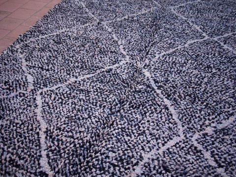 Close-up view of the black and white geometric pattern on the Beni Ourain rug.
