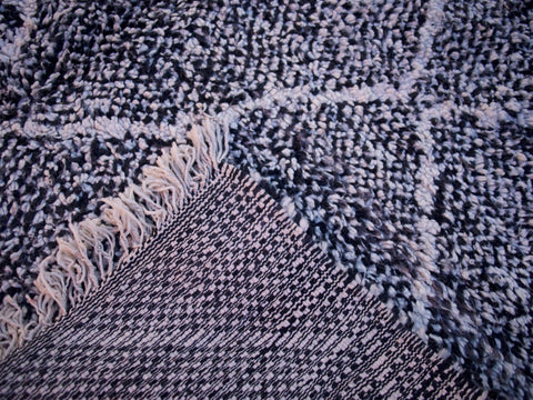 Close-up detail of the geometric pattern on the black and white Beni Ourain rug.