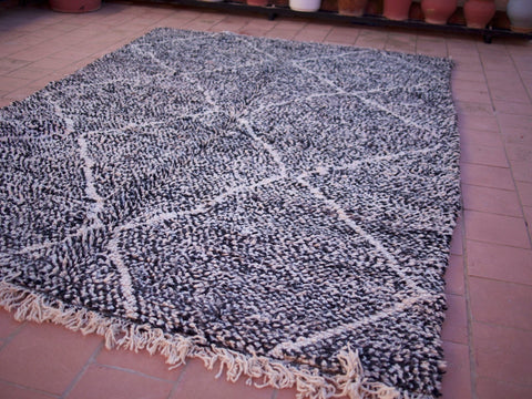 Lifestyle view of the black Beni Ourain rug showcasing its geometric design against a natural backdrop.