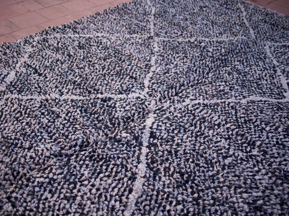 Close-up detail of the black and white geometric design on the Beni Ourain rug.