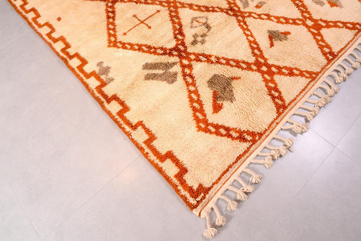 Side view highlighting the fringe and geometric design of a white and brown Moroccan Beni Ourain rug.