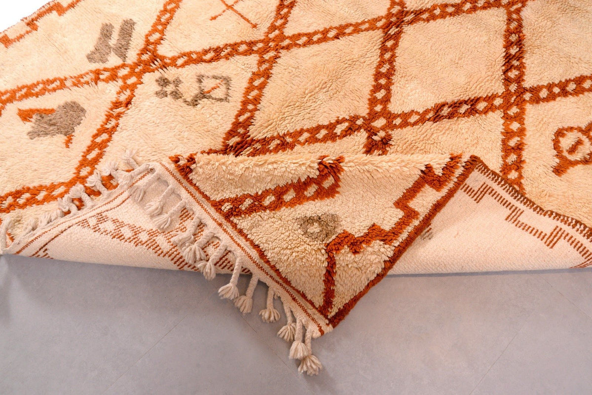 Detail view of the geometric pattern on a white and brown Moroccan Beni Ourain rug.
