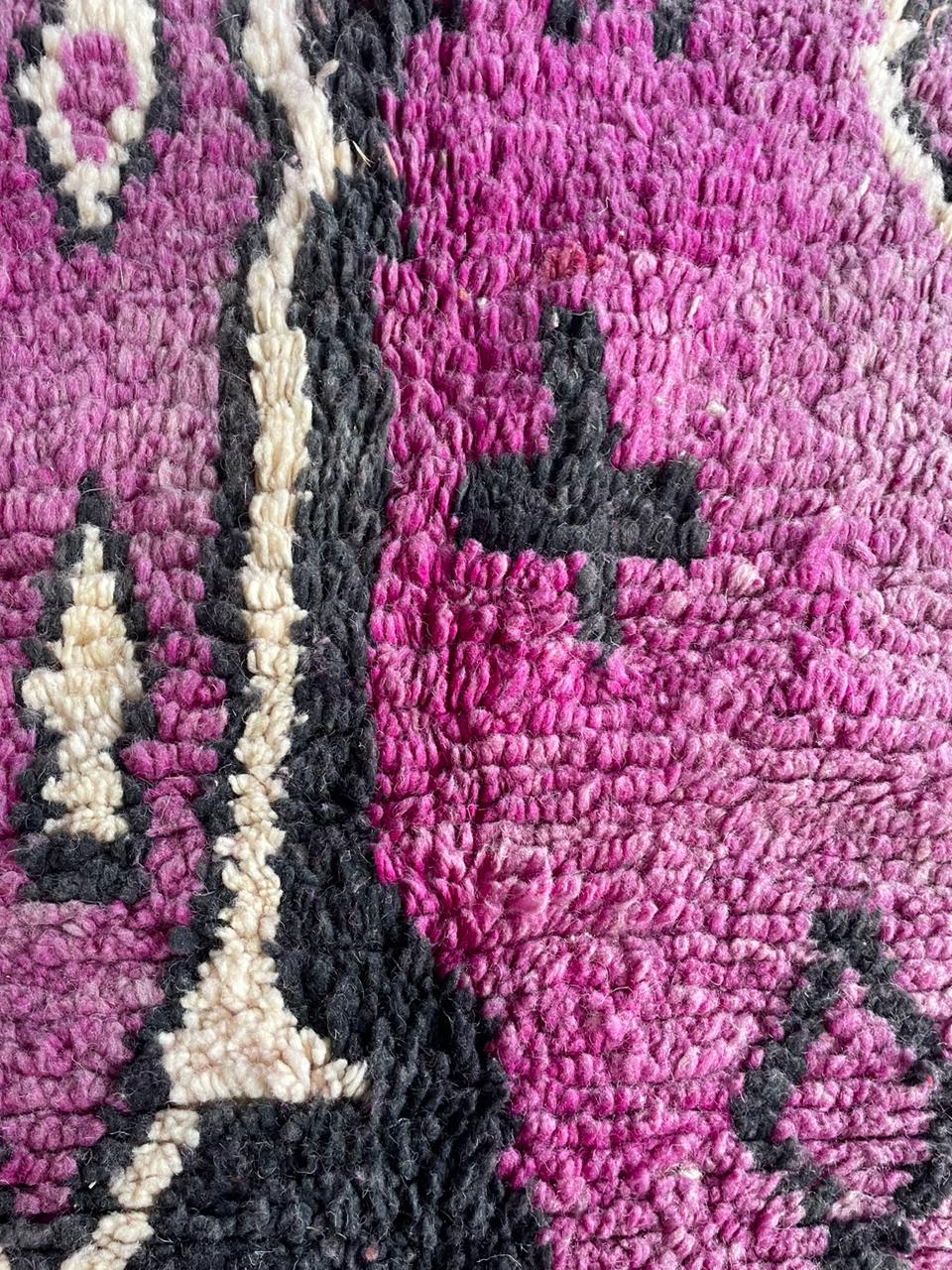 Close-up detail of a pink patterned rug showcasing geometric patterns and soft texture.