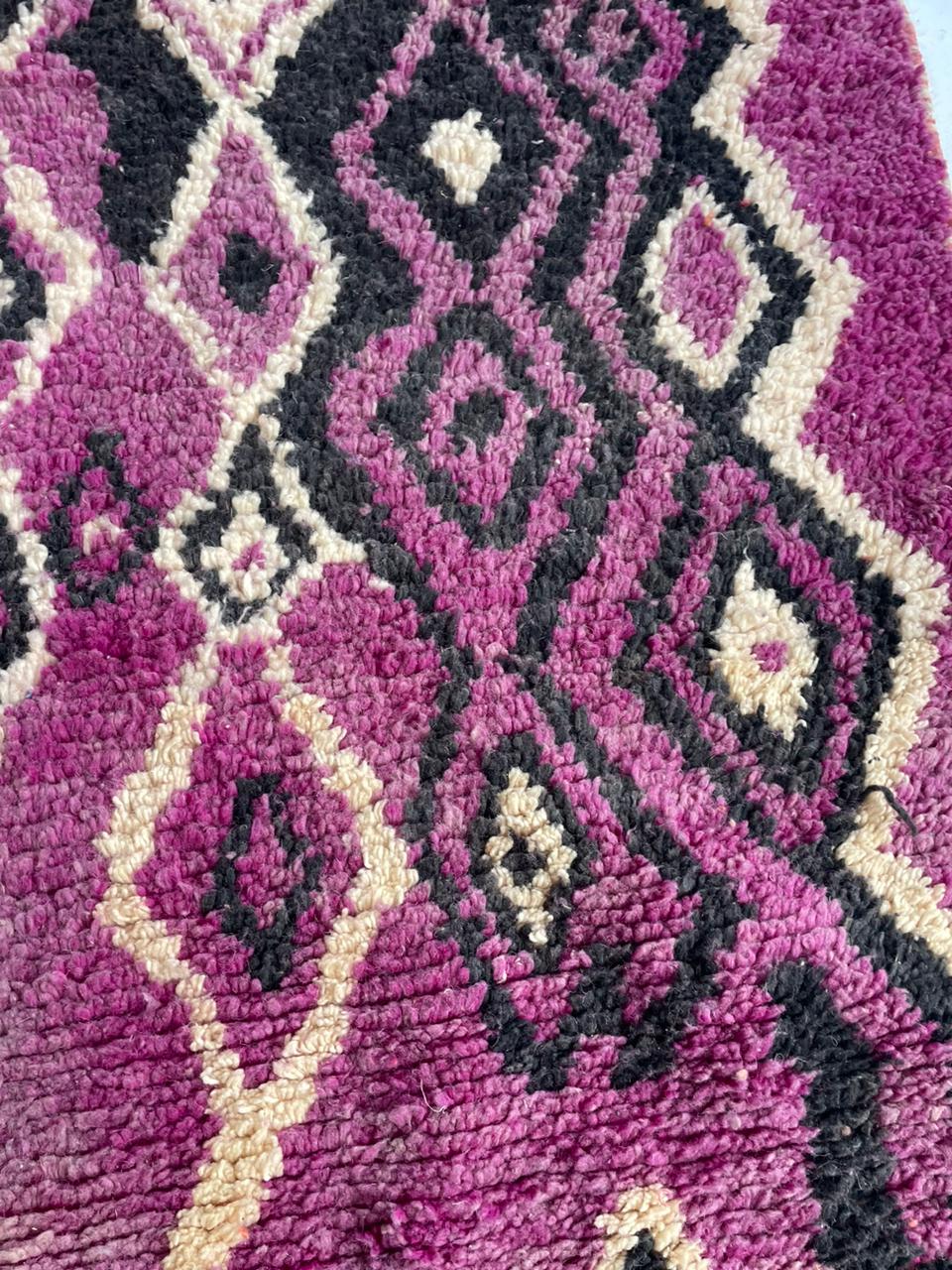 Close-up detail of a pink patterned rug with geometric patterns and soft texture.