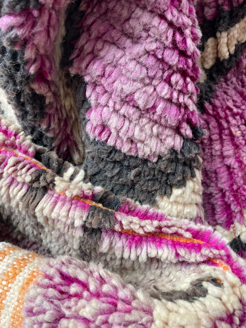 Close-up detail of the vintage wool rug showcasing geometric shapes and textured pattern.