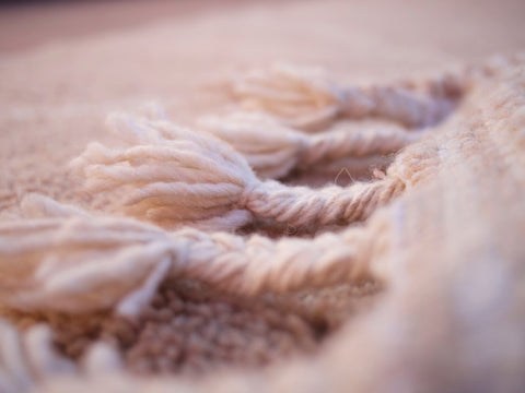 Close-up detail showing the soft texture and fringe details of the brown rug.