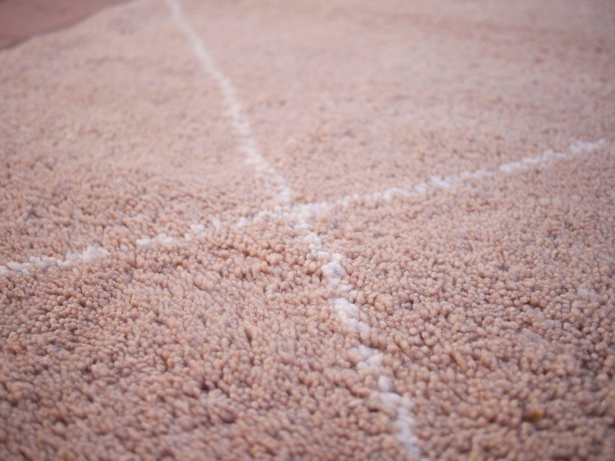 Detail close-up of the patterned design on the textured surface of the brown rug.