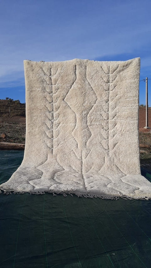 Lifestyle view of a tufted Moroccan Mrirt rug in white and beige colors.