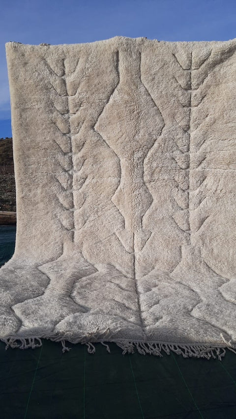 Detail view of the textured pattern on a tufted Moroccan Mrirt rug in white and beige.