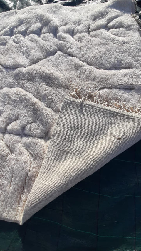 Close-up detail of the textured pattern on a tufted Moroccan Mrirt rug.