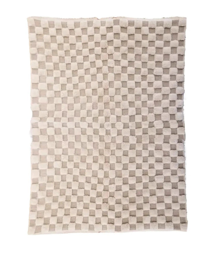 Detail close-up of a beige and brown Moroccan rug featuring a geometric pattern.