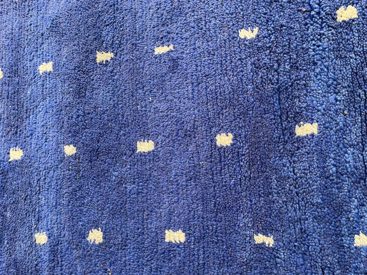 Detail shot of a blue Moroccan rug showcasing its geometric pattern.