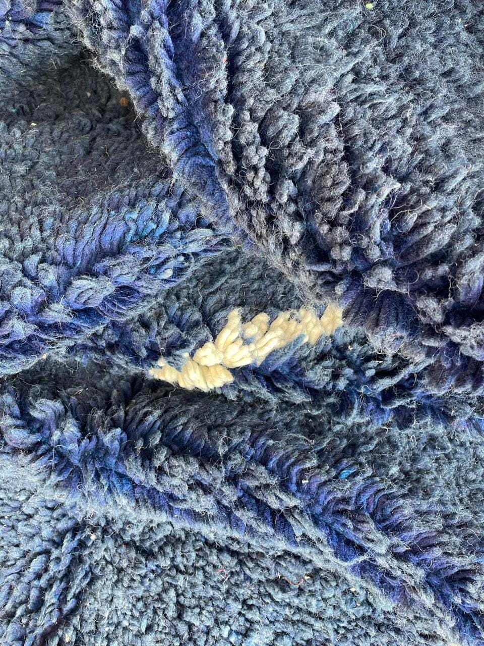 Close-up detail of a blue Moroccan rug with a textured surface.
