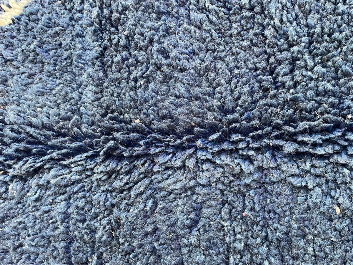 Close-up detail of a blue Moroccan rug with a textured surface.