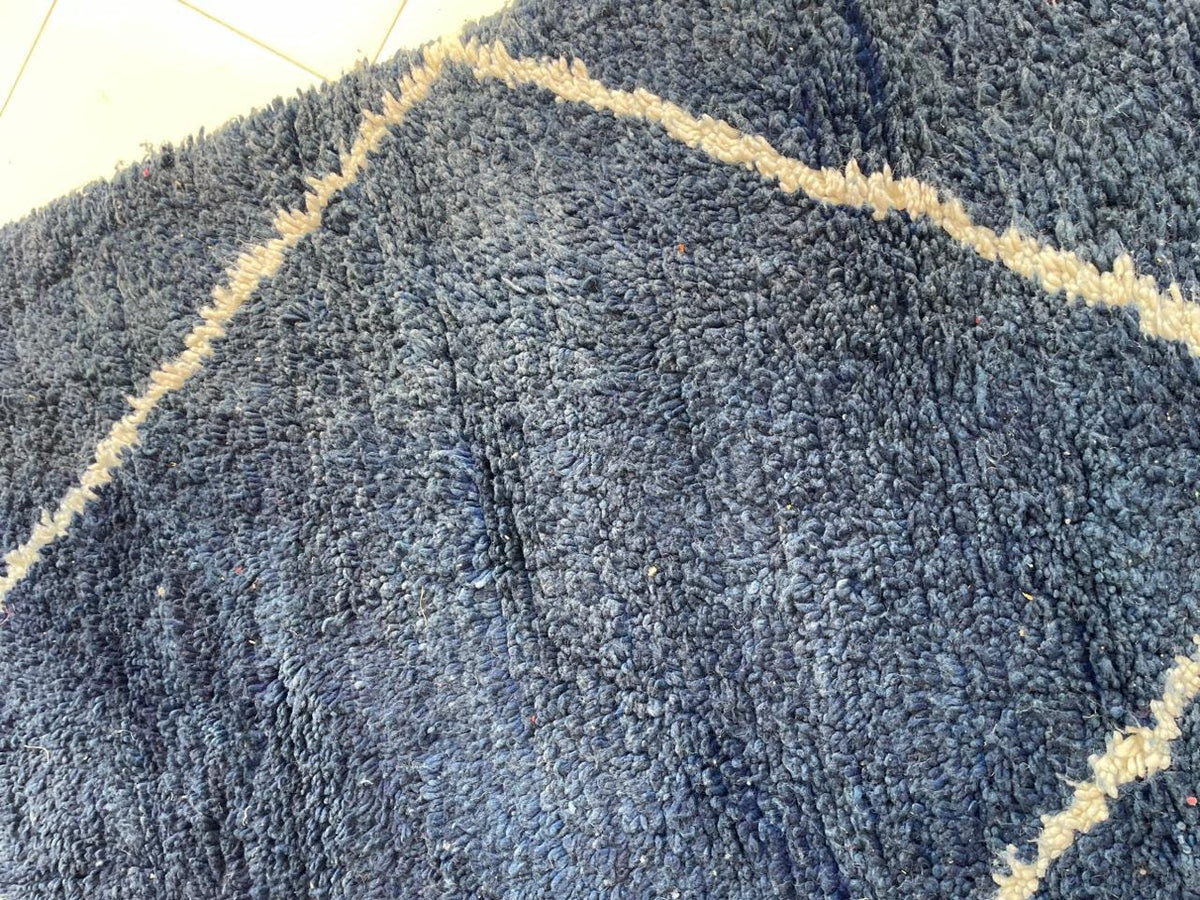 Close-up detail of a blue Moroccan rug highlighting a geometric pattern.