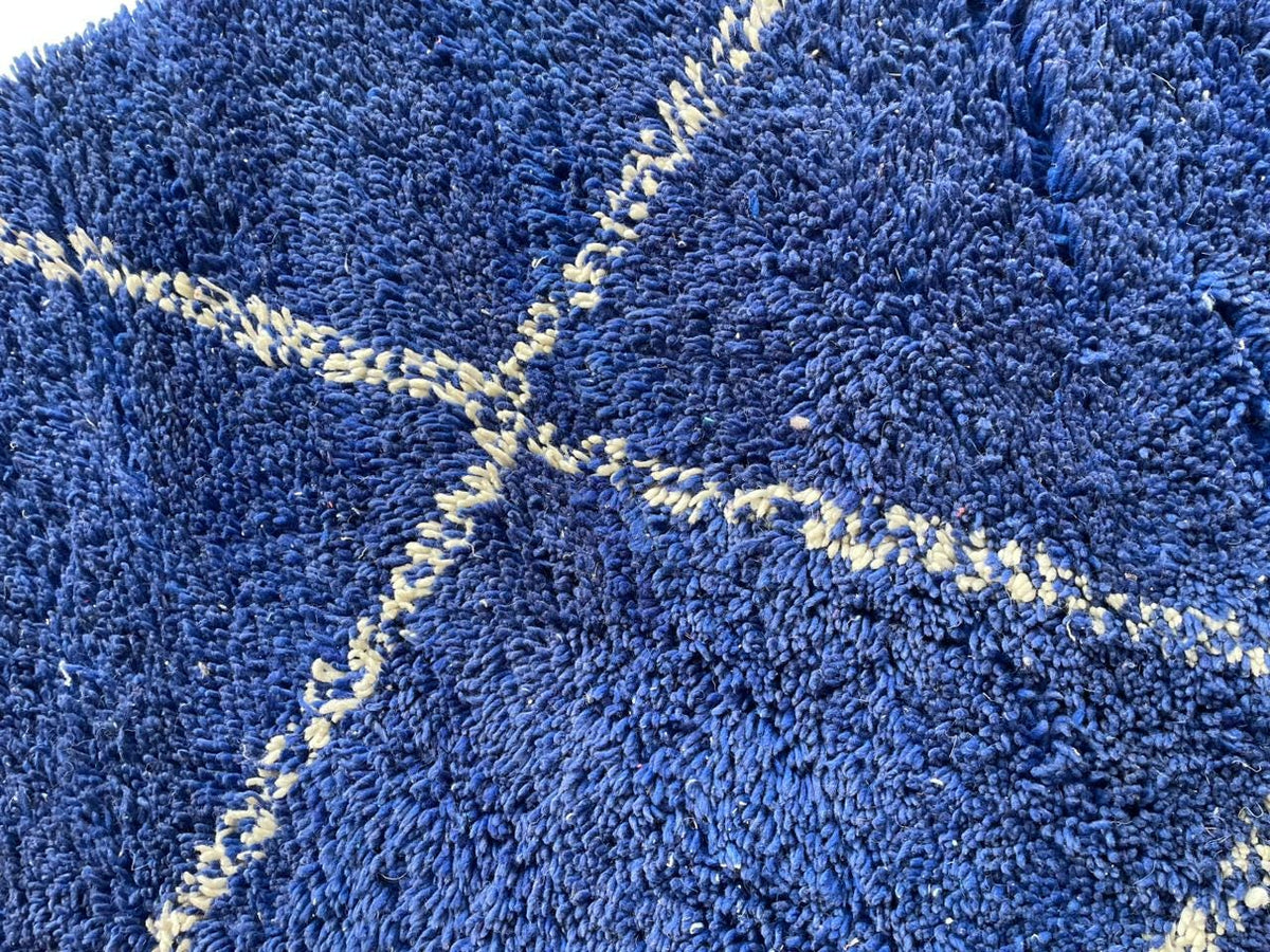 Detail close-up of the blue Moroccan rug with a diamond pattern.