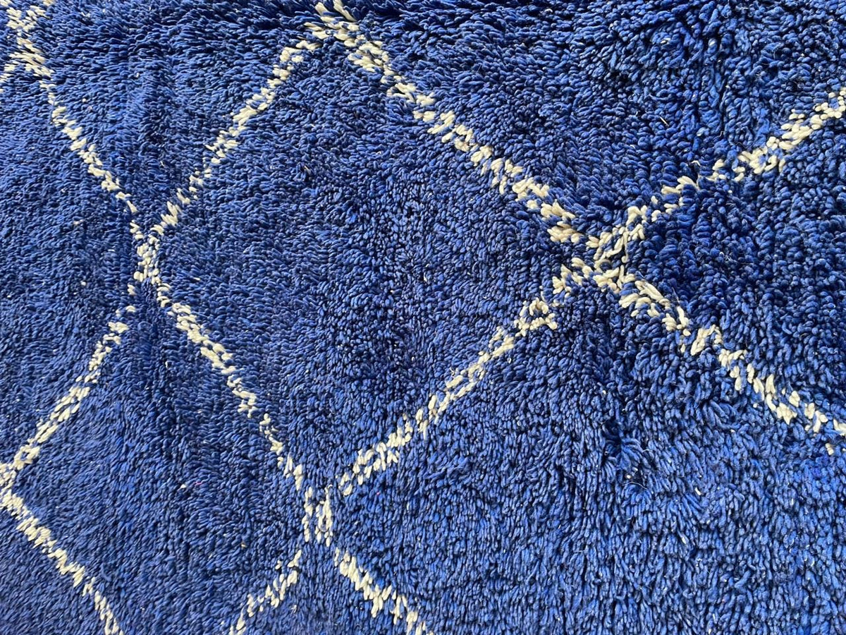 Detail close-up of the blue Moroccan rug showcasing its geometric pattern.