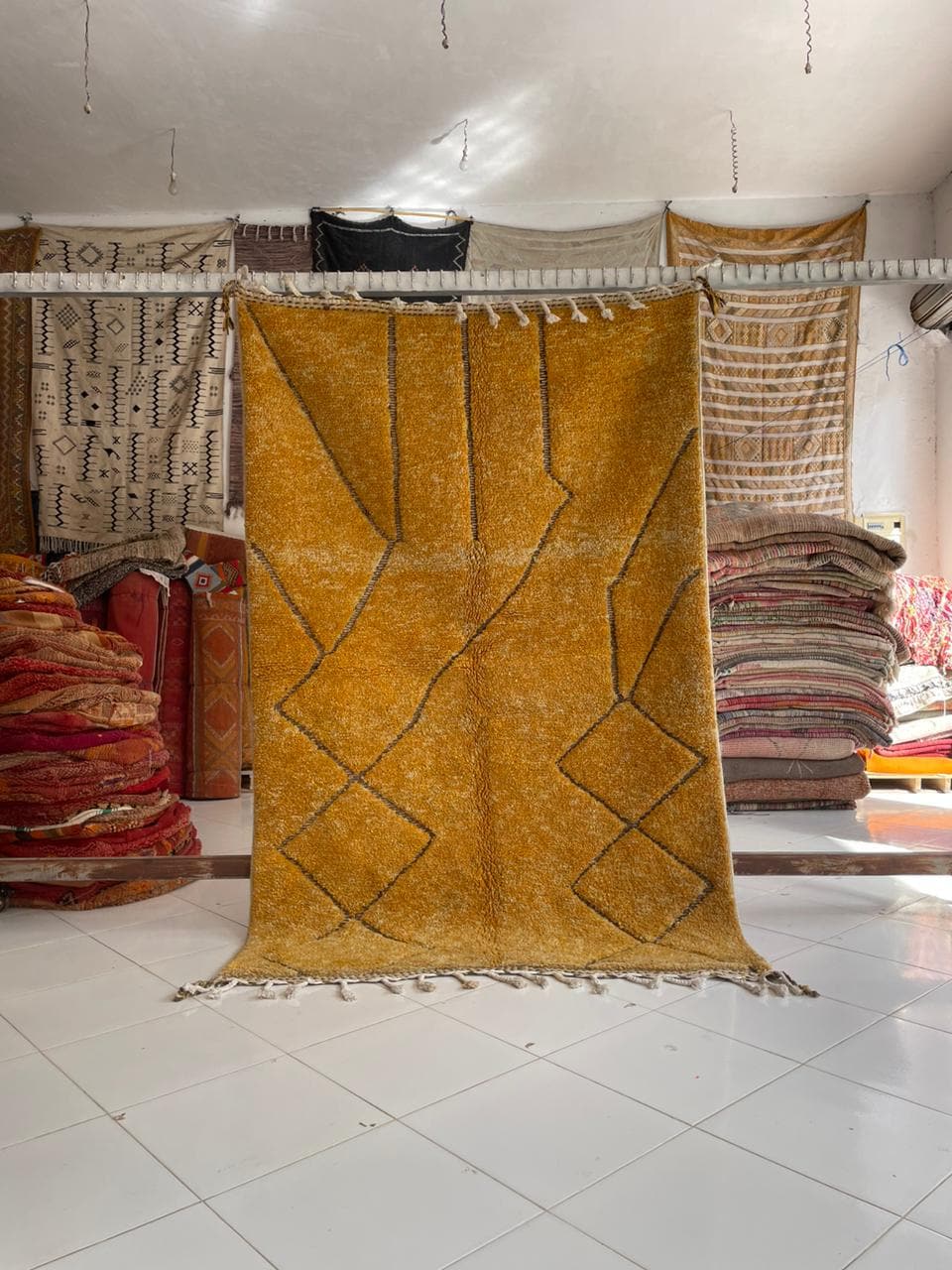 Lifestyle shot of a yellow Moroccan rug with fringe edges in a natural setting.