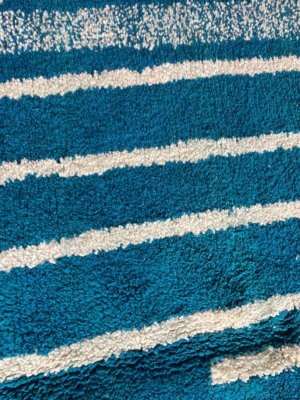 Close-up of a blue striped Moroccan rug displaying a soft texture.