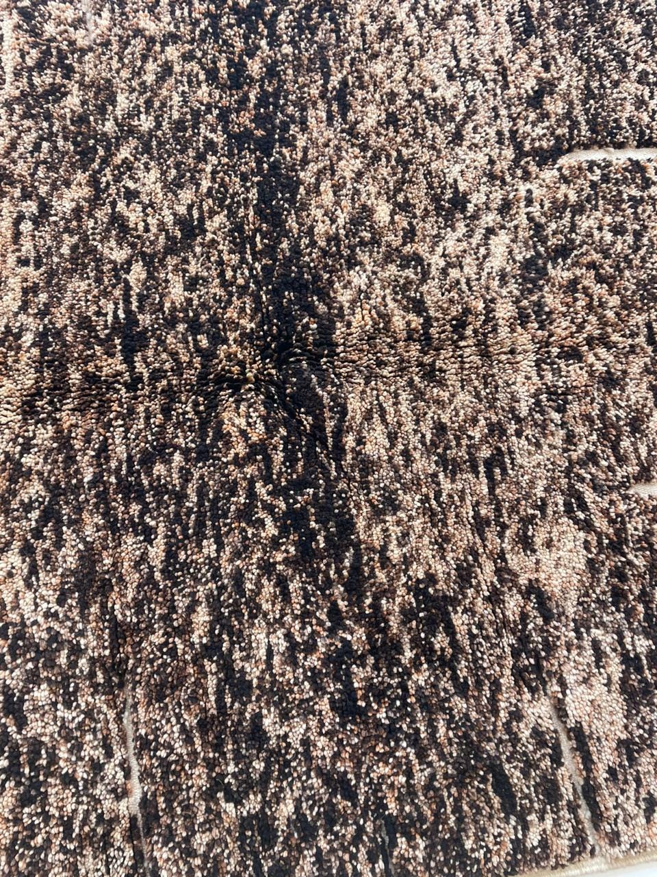Detail view of a brown Moroccan rug showcasing its textured pattern on a contrasting background.