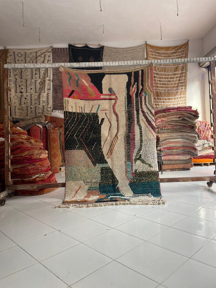 Lifestyle shot of a colorful Moroccan rug featuring varied patterns in red, black, white, and blue.