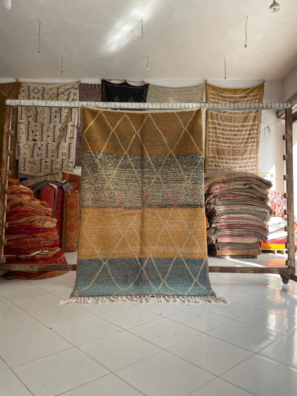 Lifestyle shot of colorful Moroccan rug with various patterns in red, brown, and blue.
