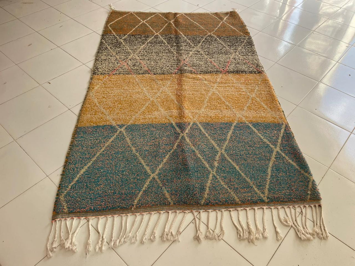Front view of a Moroccan rug featuring geometric designs in blue, gold, and white.