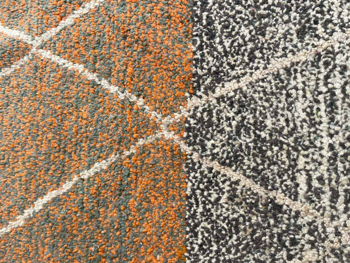 Close-up detail of the woven texture with orange and gray patterns on the rug.