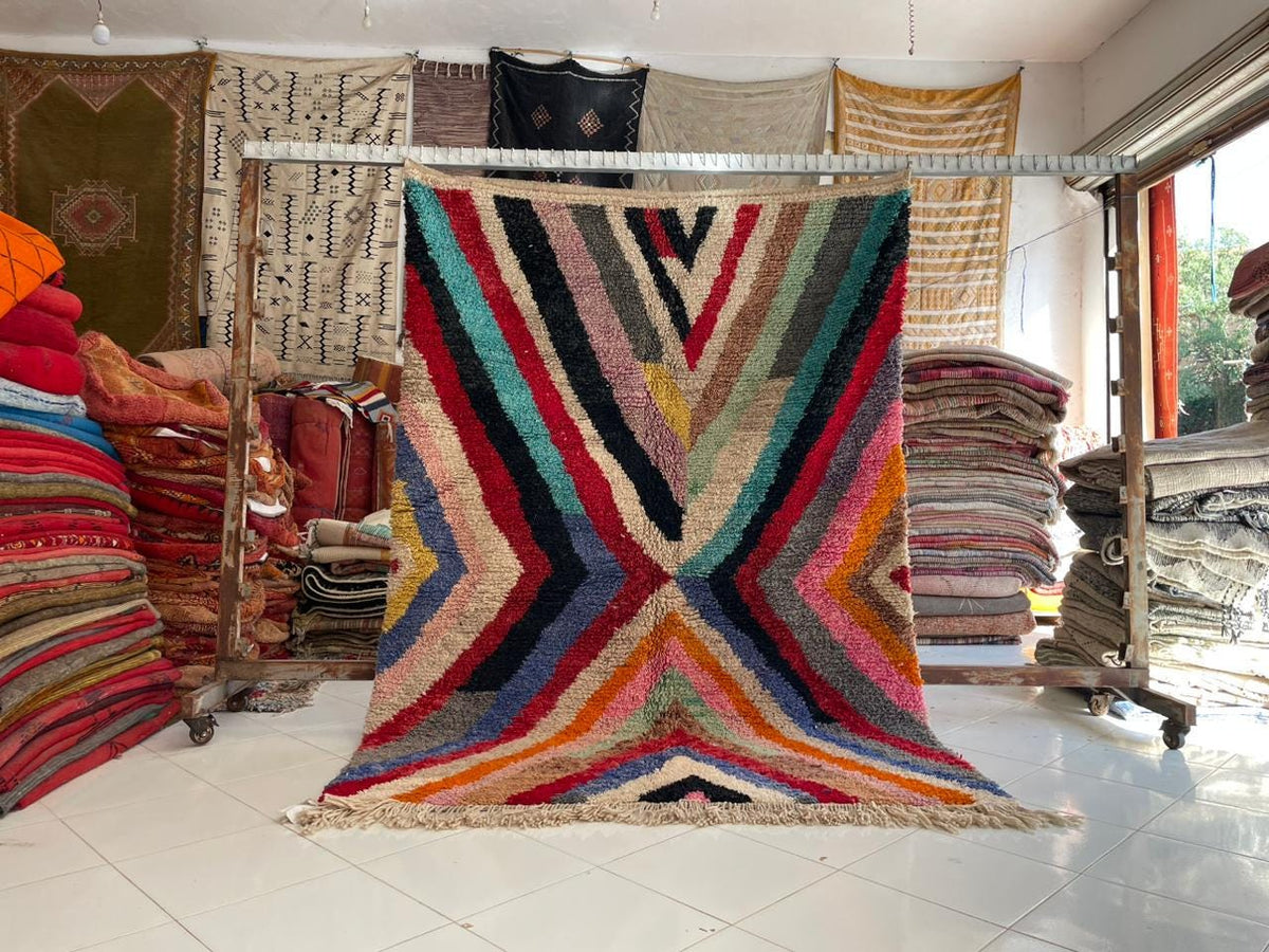 Lifestyle shot of a striped rug in red, blue, yellow, and black, emphasizing bold stripes.