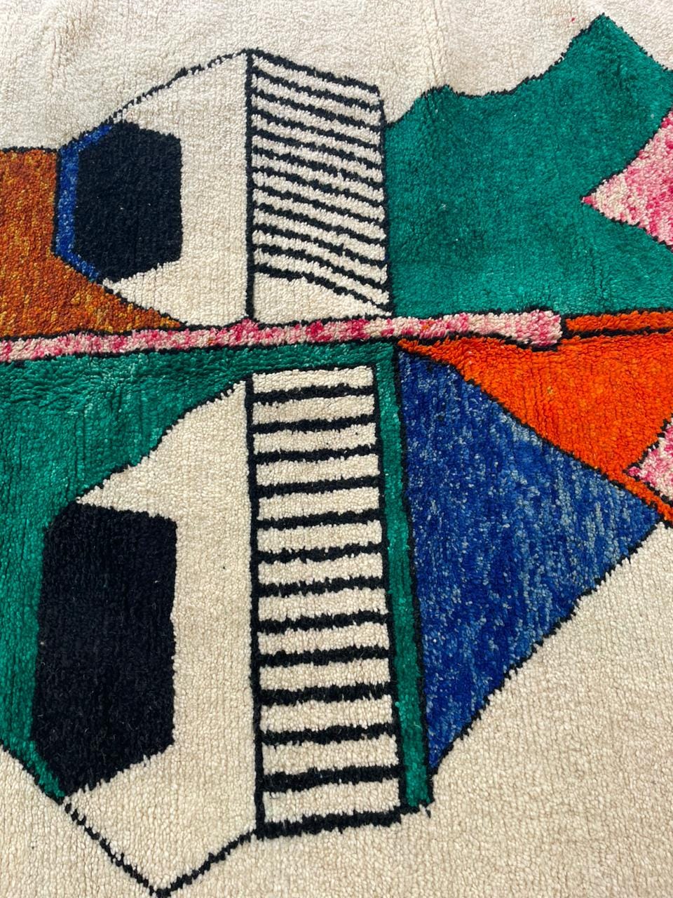 Detail close-up of a colorful Moroccan rug with an abstract design and textured surface.