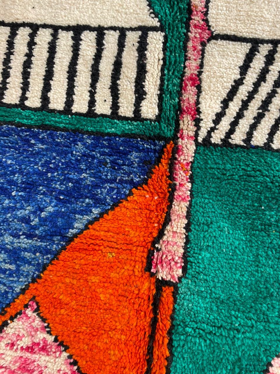 Detail close-up of a colorful Moroccan rug highlighting its abstract design and texture.