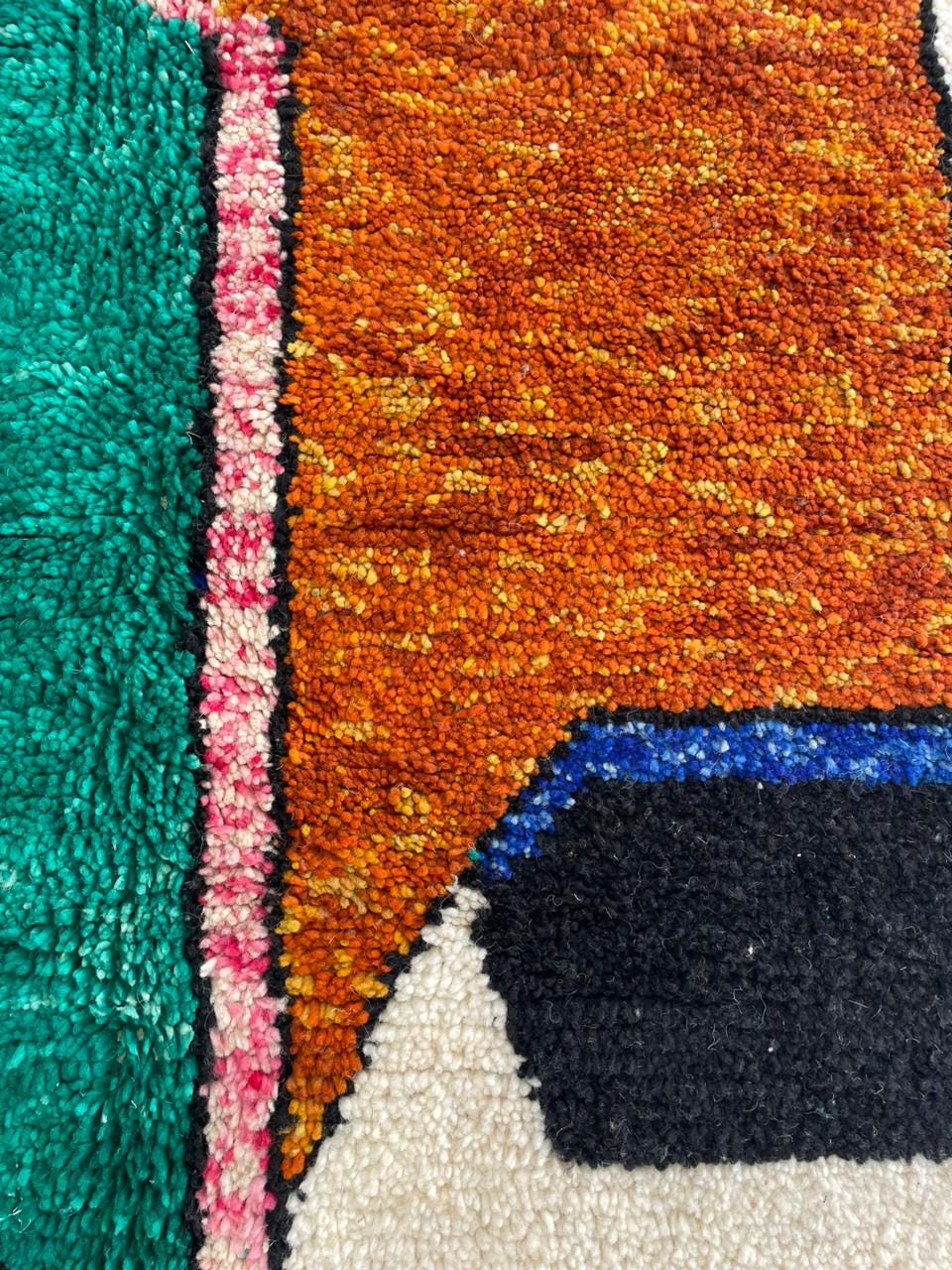 Detail close-up of a colorful rug showcasing an abstract design and soft texture.