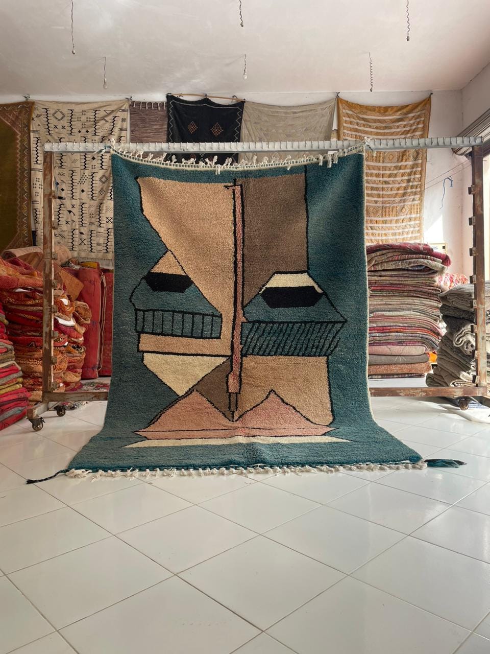 Lifestyle shot of a colorful Moroccan rug featuring geometric patterns in blue, brown, and cream.