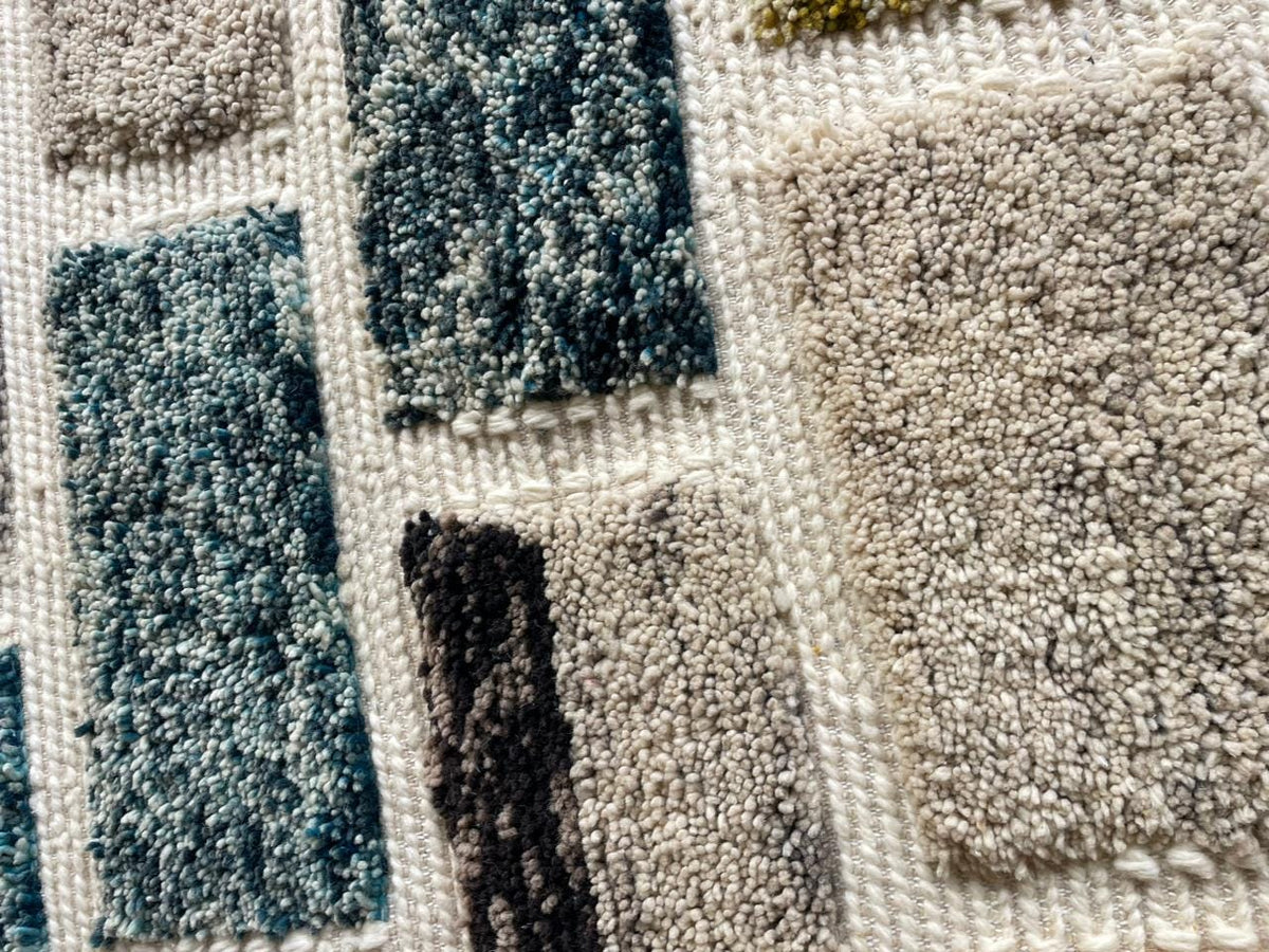 Detail view of a textured Moroccan rug featuring geometric patterns in blue and gray.