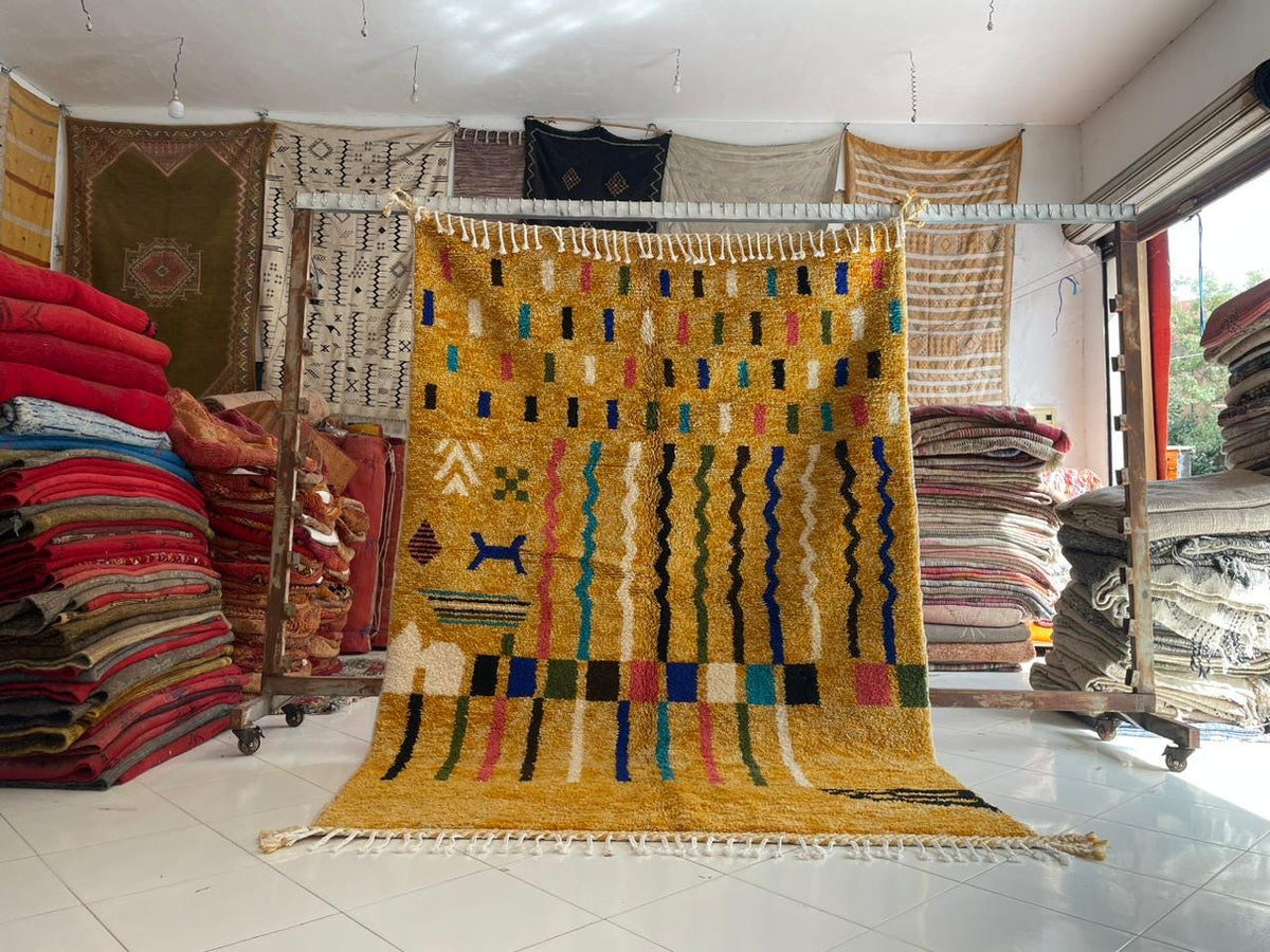Lifestyle shot of a colorful Moroccan rug with varied patterns in yellow, red, blue, and green.