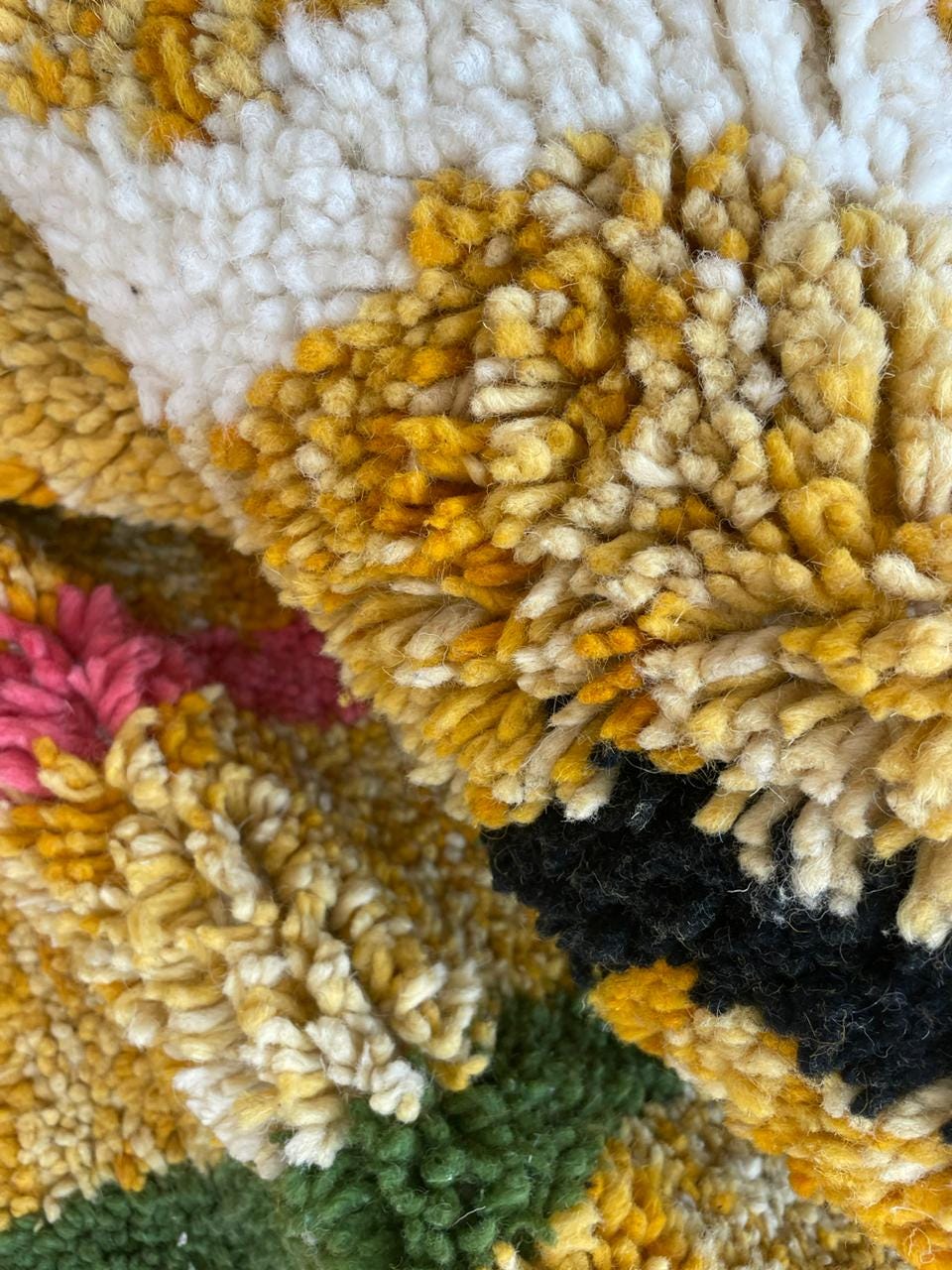 Detail close-up of a colorful Moroccan rug featuring an abstract pattern in yellow, blue, pink, and black.