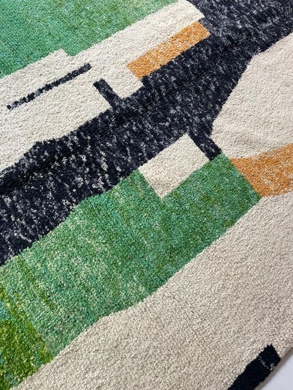 Close-up detail of the textured surface of the colorful Moroccan rug with color blocks.