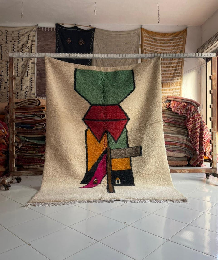Lifestyle shot of a colorful Moroccan rug featuring geometric patterns and fringe edges.