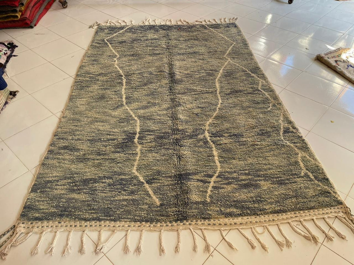 Top view of a gray Moroccan rug showcasing its patterned design in a studio.