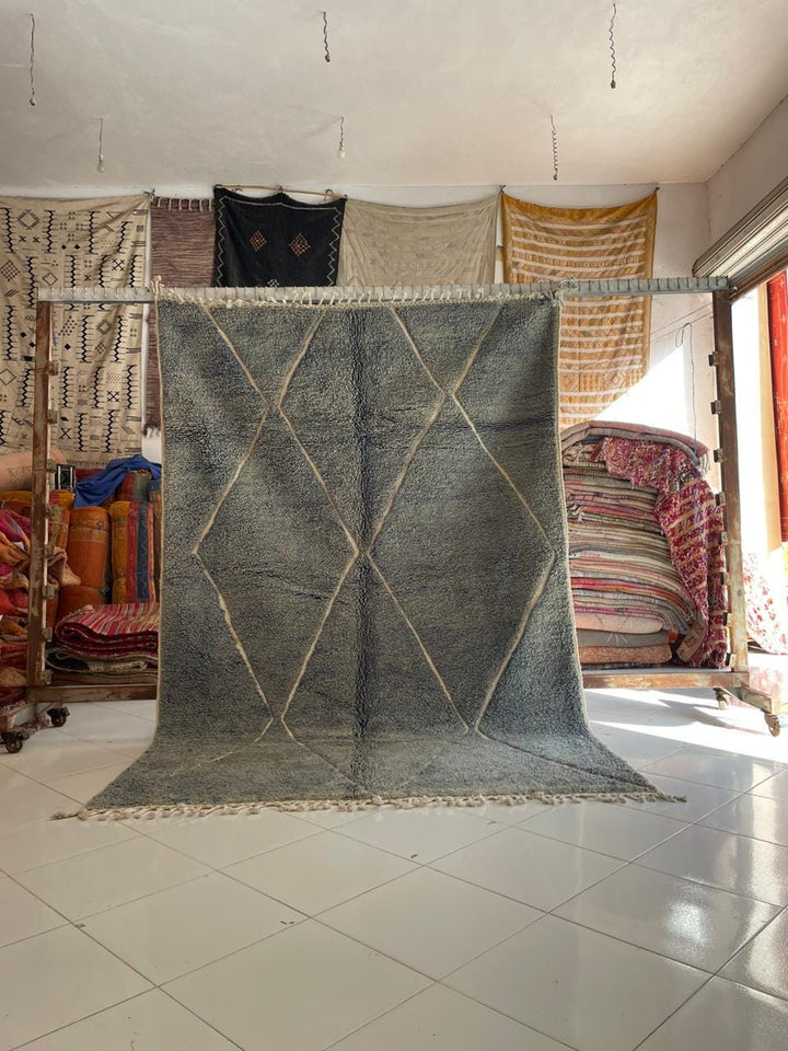 Lifestyle shot of a gray Moroccan rug with a bohemian style in a natural setting.