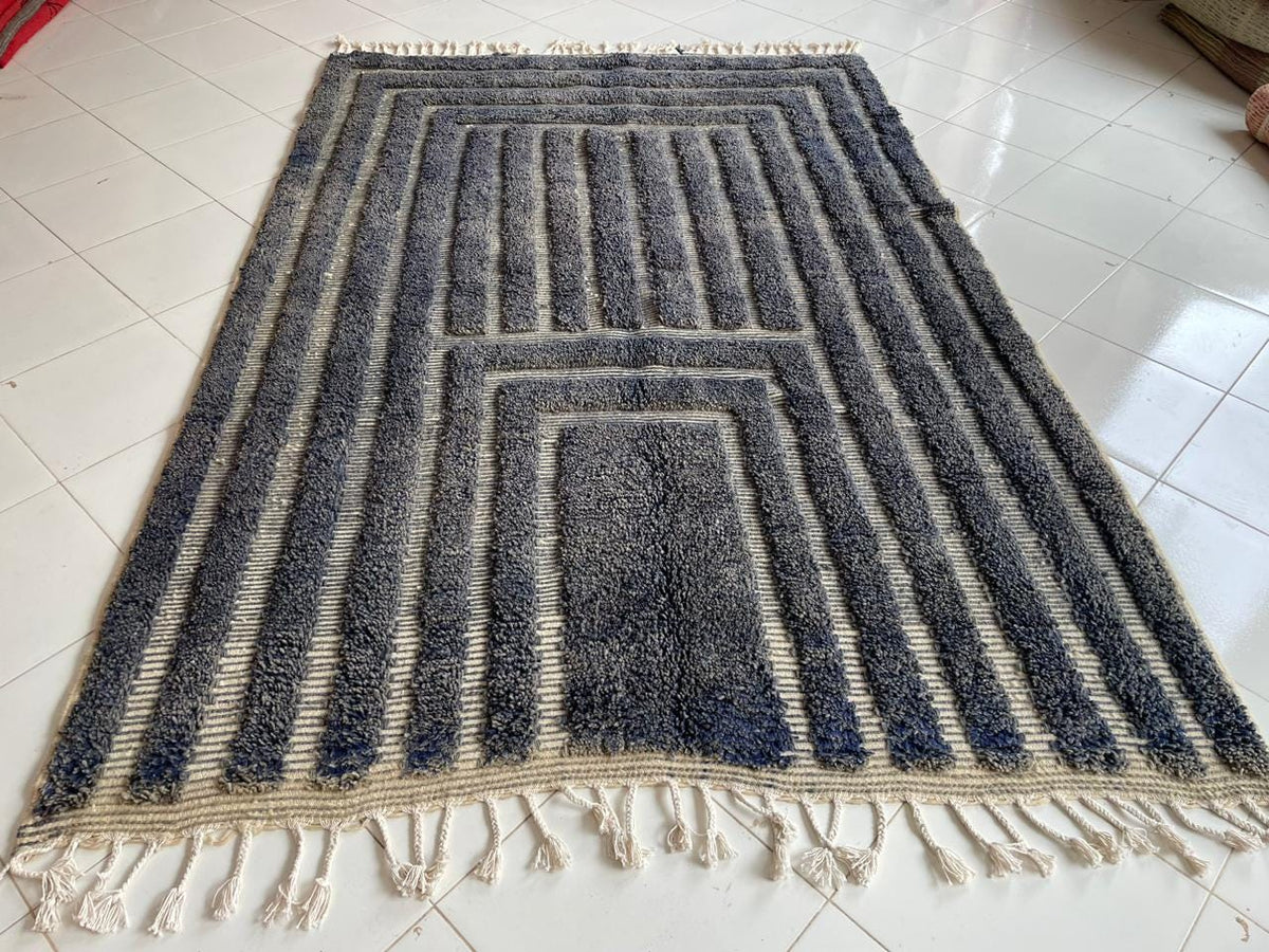 Front view of a gray Moroccan rug showcasing its geometric design and fringed edges.