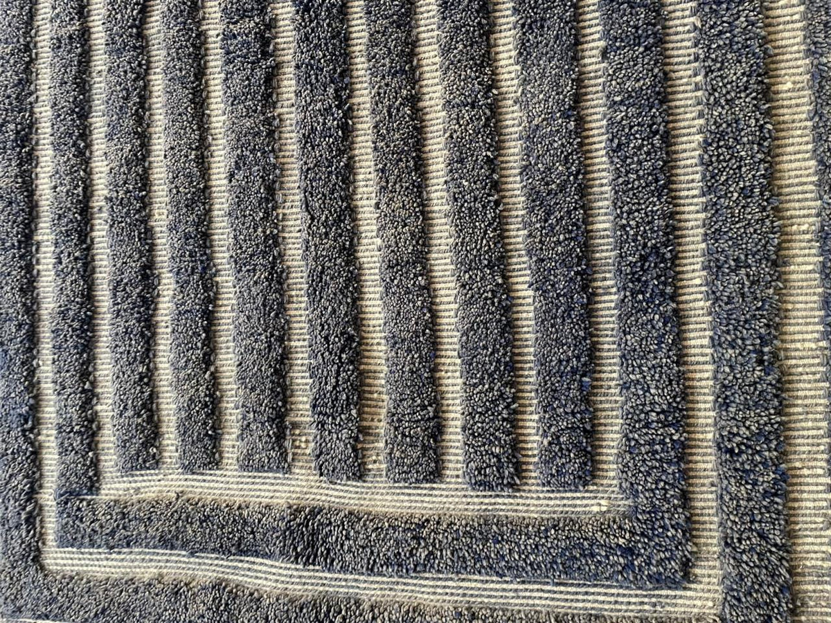 Detail close-up of a gray Moroccan rug highlighting its textured surface and striped pattern.