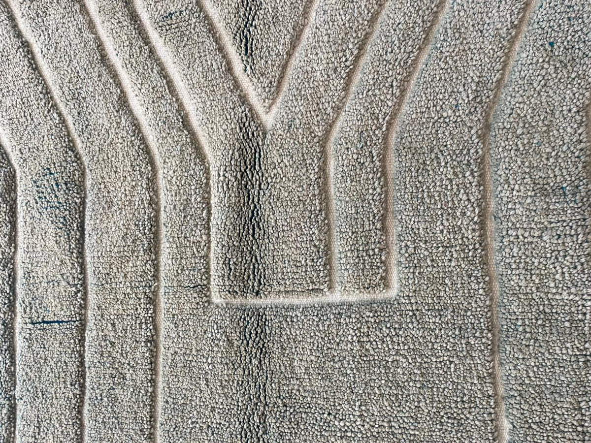 Close-up detail of a gray Moroccan rug showcasing its textured pattern and fringed edges.