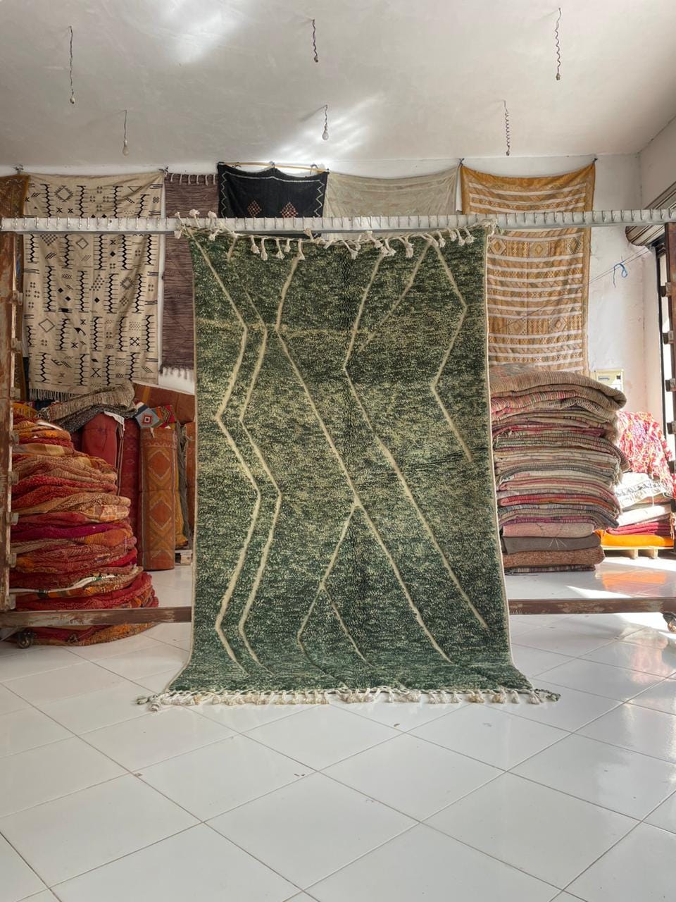 Lifestyle shot of a green Moroccan rug with geometric patterns in a natural setting.