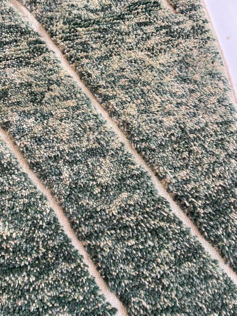 Detail shot of a green Moroccan rug showcasing a textured pattern.