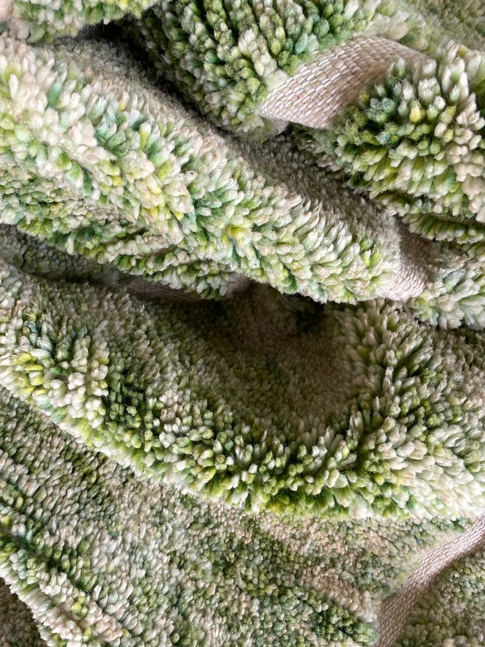 Close-up detail of the textured surface of a green rug.